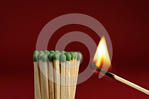 Burning match near unlit ones on background