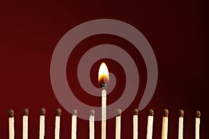 Burning match among unlit ones on background, closeup