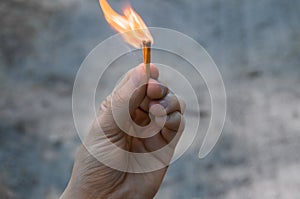 Burning matches in left hand. The flame from the matches pointing to the up.