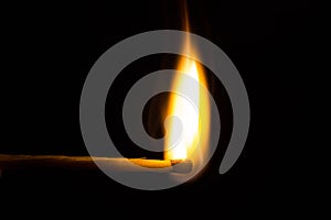 burning matchstick on black background