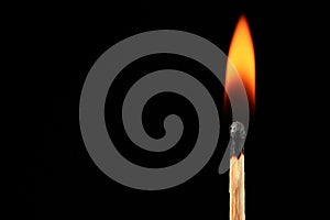 Burning matchstick on black background, fire flame in the dark