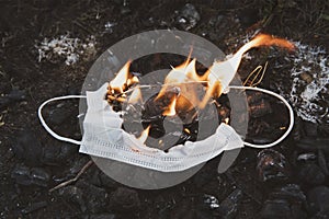 Burning medical mask, surgical mask with cleansing decontaminate fire. Concept of End of Chinese coronavirus pandemic. photo