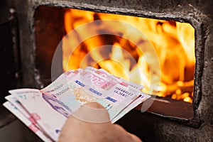 Burning money in solid fuel boiler as a symbol of high expenses for heating the house