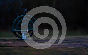 Burning of the mosquito coil in nature. Mosquito-repelling incense with a whiff of smoke, banner, copy space