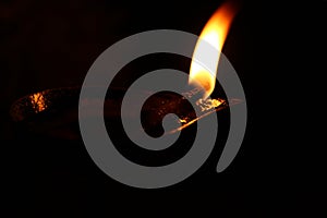 Burning oil lamp and fire with dark background. Closeup.