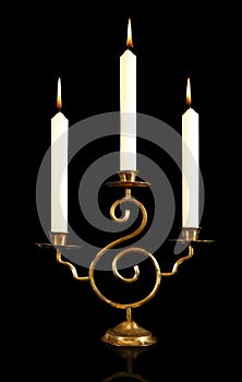 burning old candle vintage bronze candlestick. Isolated Black Background.