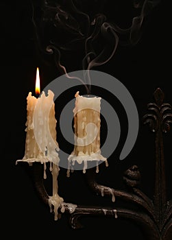 Burning old candle vintage Silver bronze candlestick. Isolated Black Background.