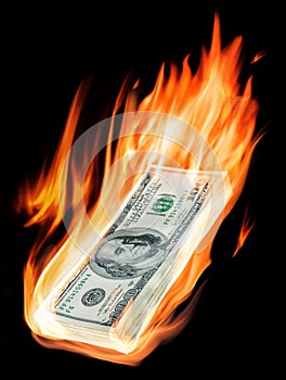 Burning one-hundred dollar bills in flames on black background