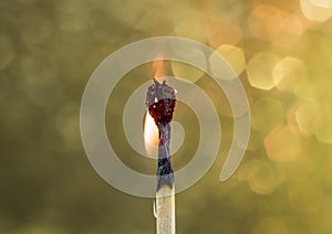 Burning Out Match Gold Bokeh Background