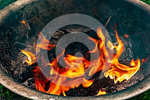 Burning plastic and wood burn in an iron container and emit harmful smoke into the atmosphere