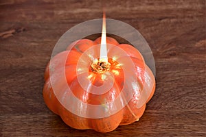 Burning pumpkin-shaped candle