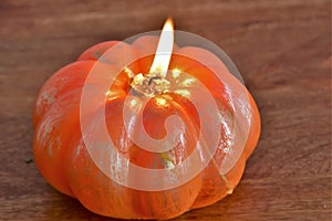 Burning pumpkin-shaped candle