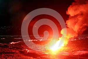 Burning red flare, flame, football hooligan. football fans lit up the lights and smoke bombs on the football pitch. Burning red fl