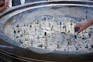 Burning religious candles in front of Japanese temple (Shrine) in Tokyo as a symbol of Eastern traditions