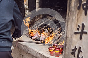 Burning the silver and gold fake money paper for Chinese dead people ancestors. Joss paper money burning metal bucket