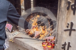 Burning the silver and gold fake money paper for Chinese dead people ancestors. Joss paper money burning metal bucket