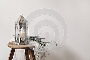 Burning silver Moroccan, Arabic lantern. Dry palm leaf and cotton cloth on wooden stool. Greeting card for Muslim