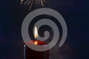 Burning single red candle with dancing flame on the dark background