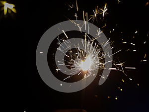 Burning sparkler producing spark around, celebration with fireworks and crackers during X mas and new year