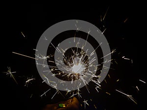 Burning sparkler producing spark around, celebration with fireworks and crackers during X mas and new year