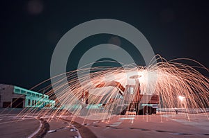 Burning steel wool on the excavator, winter night landscape,