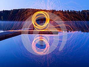 Burning steel wool spinning, showers of glowing sparks from spinning steel wool