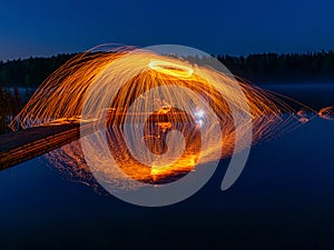Burning steel wool spinning, showers of glowing sparks from spinning steel wool