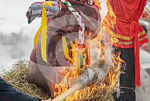 A burning stick with straw that sets fire to a female effigy photo