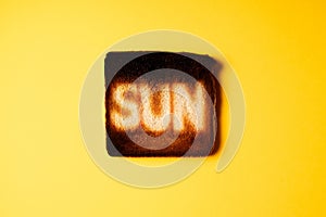 Burning sun. burnt slices of white bread toast with the word Sun on it on yellow background.