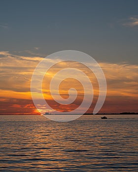 Burning sunset over the sea Ã–resund outside Sweden with nuclear power plant BarsebÃ¤ck on the horizon