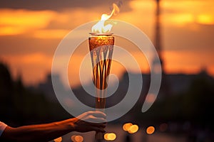 Burning torch in a hand of athlete as a symbol of the Olympic Games in Paris, France, Eiffel tower on background. Olympic games photo