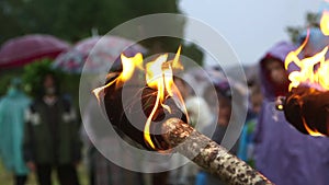 burning torch, summer solstice festival, people in background