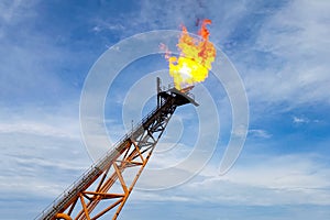 Burning torch at the torch plant burning associated natural gas on the oil platform photo