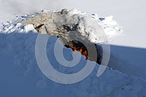 Burning trash in the snow. Bonfire in a snowdrift. A place for incineration of household waste in the garden