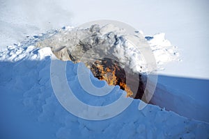 Burning trash in the snow. A place for incineration of household waste in the garden. Bonfire in a snowdrift