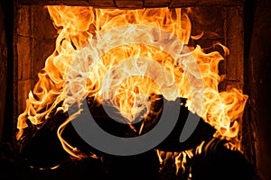 Burning wood. Cozy fire with logs. Glowing fireplace. Fire texture. Flame background. Abstract flames.