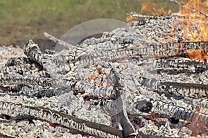 Burning wood in huge bonfire. Natural background of fire and ashes with copy space photo