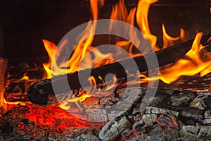 Burning wood at night. Flame and fire sparks on dark abstract background. Cooking barbecue outdoor.