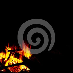 Burning wood at night, flame and fire sparks on dark abstract background, photo leaving place for imagination and meditations