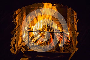 Burning wood in open fire place. Red flames in the fireplace