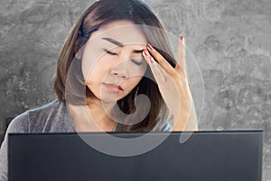 burnout Asian woman have headache migraine while working on computer, photo