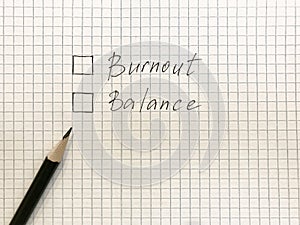 burnout or balance chechboxex on checkered sheet of paper. Black pencil near to choose. Burnout at work concept