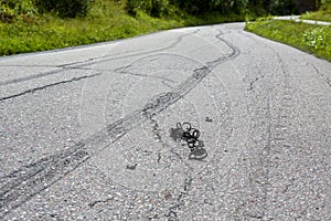 Burnout marks on the asphalt road with tire pieces
