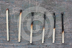 Burnout syndrome concept. Burned matches on a rough wooden background. Top view. Copy space