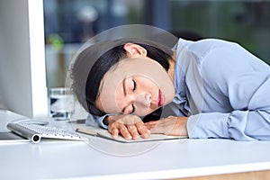 Burnout, tired and business woman sleeping on the desk in her modern office while planning a strategy. Fatigue