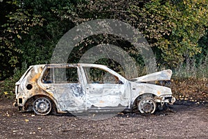 The burnout wreck of a car in a quiet countrylane