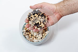 Burnt black popcorn in a blue cup.man touching burnt popcorn, hand close up