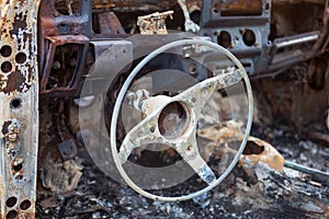 Burnt car interior with steering wheel after the accident