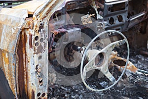 Burnt car interior with steering wheel after the accident