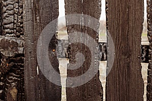 Burnt fence boards after a fire in a private house.